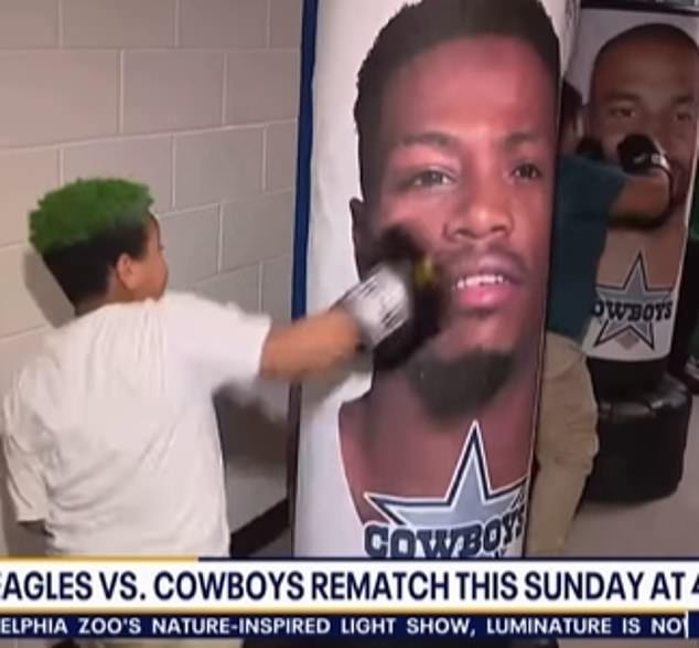 Los espectadores se sorprenden cuando los jóvenes fanáticos de los Eagles animan a los sacos de boxeo vestidos como estrellas de los Cowboys.