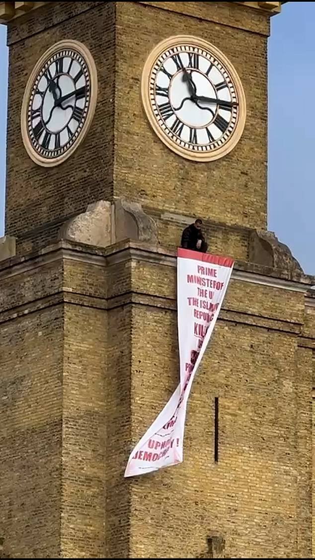 Manifestante iraní escala la estación King’s Cross de Londres y despliega una pancarta exigiendo acción a Keir Starmer