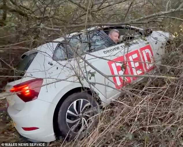 El momento en que un profesor de conducción ebrio refunfuñó al volante de su coche de pruebas, después de que la policía descubrió que se había estrellado contra unos arbustos en medio de una zanja.